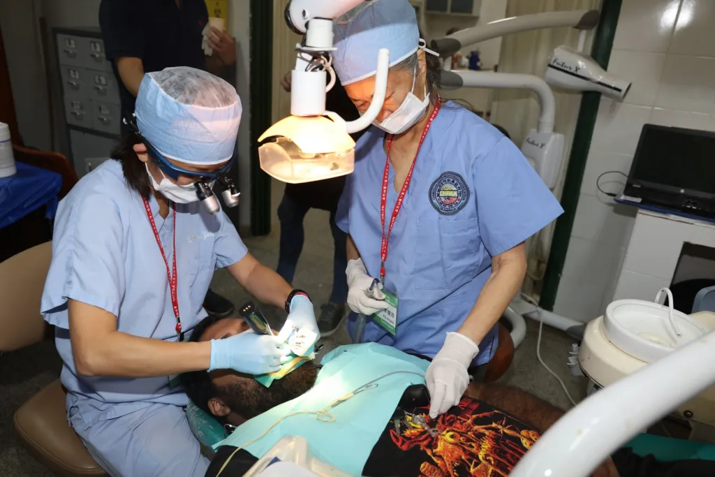 Dr. Yeh and a staff member doing charity work on a patient