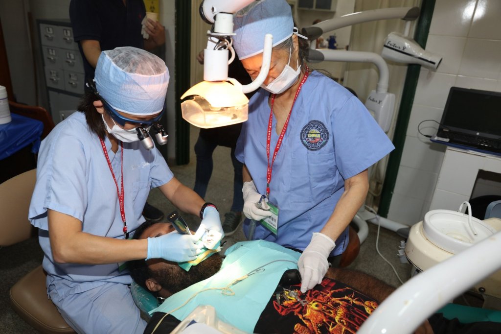 Dr. Yeh and a staff member doing charity work on a patient